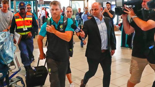 David Warner faces a media pack as he arrives in Johannesburg. (EPA/AAP)