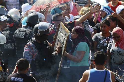 Protestors argue with police outside the Anisio Jobim Prison Complex where a riot erupted among inmates in the northern state of Amazonas, Brazil, Sunday.