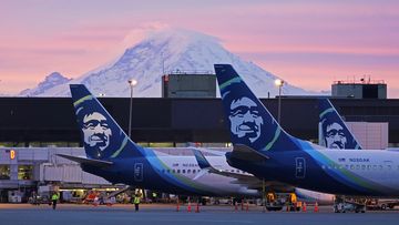 FILE - Alaska Airlines planes are shown parked at gates with Mount Rainier in the background at sunrise, March 1, 2021, at Seattle-Tacoma International Airport in Seattle.  (AP Photo/Ted S. Warren, File)