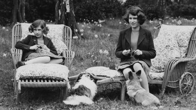 Princess Elizabeth (now Queen Elizabeth II, right) and her younger sister Princess Margaret Rose (1930 - 2002) knitting for the forces in the grounds of the Royal Lodge in Windsor Great Park, April 1940