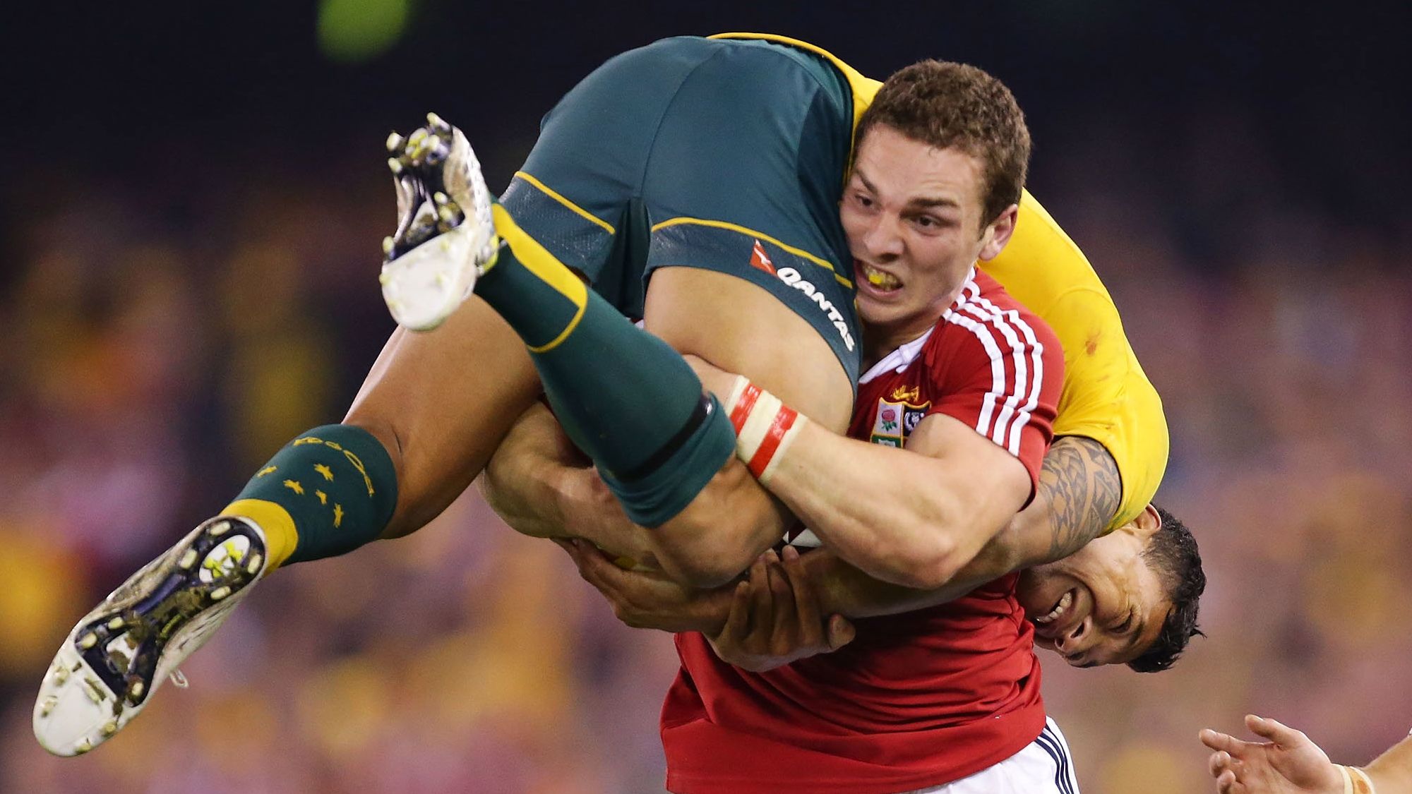 George North of the Lions lifts Israel Folau while carrying the ball during game two of the 2013 Test series against the Wallabies in Melbourne.