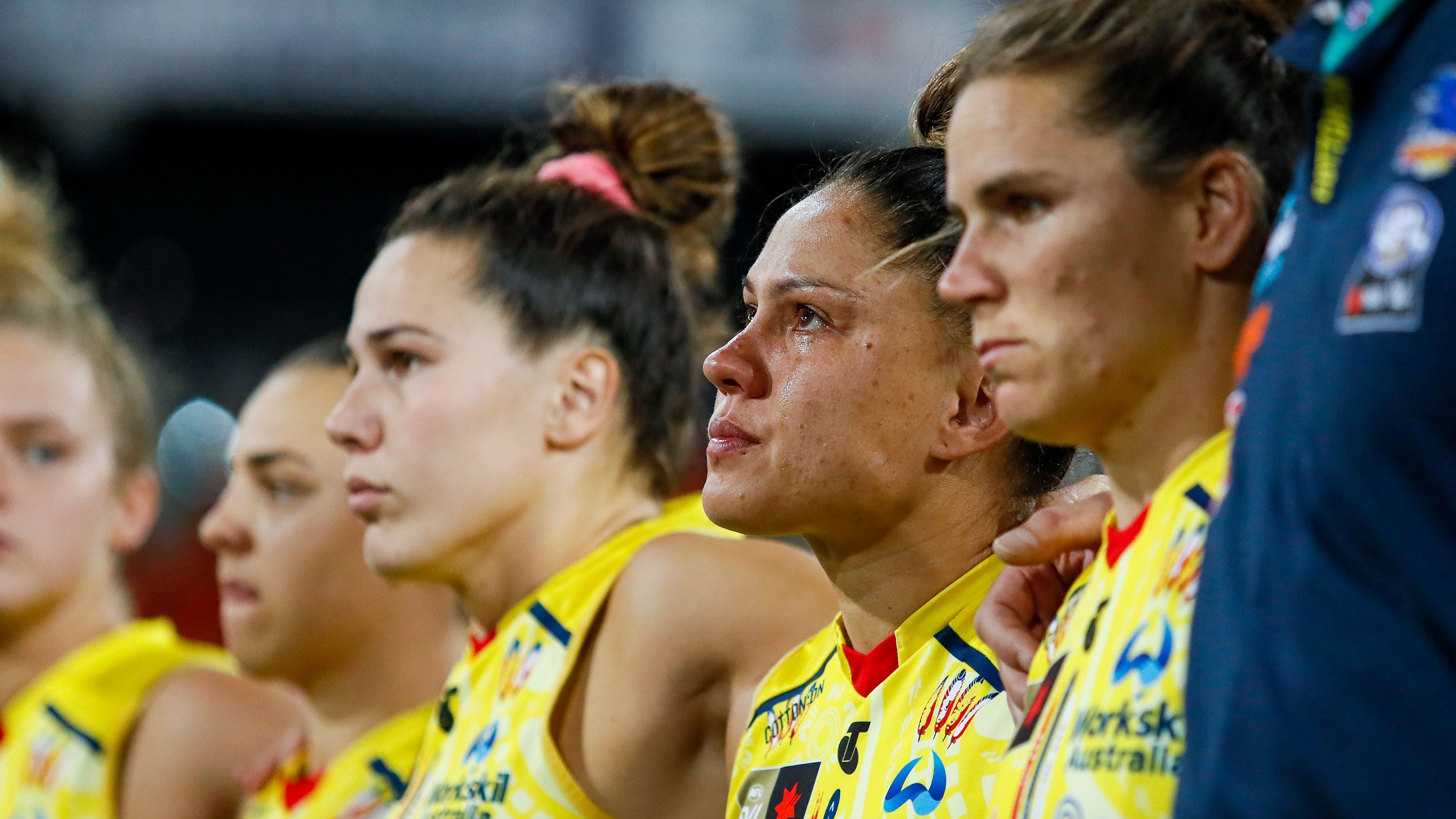 GOLD COAST, AUSTRALIA - NOVEMBER 18: Stevie-Lee Thompson of the Crows is seen getting emotional during a moments silence for former teammate Heather Anderson who passed away earlier in the week before the 2022 S7 AFLW First Preliminary Final match between the Brisbane Lions and the Adelaide Crows at Metricon Stadium on November 18, 2022 in the Gold Coast, Australia. (Photo by Dylan Burns/AFL Photos)