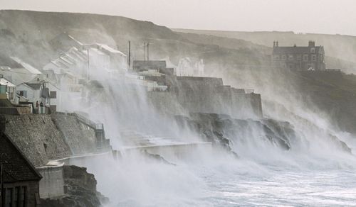 Waves hits Porthleven on the Cornish coast, Britain, as Storm Eunice makes landfall Friday, Feb. 18, 2022. Millions of Britons are being urged to cancel travel plans and stay indoors Friday amid fears of high winds and flying debris as the second major storm this week prompted a rare red weather warning across southern England. (Matt Keeble/PA via AP)