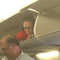 An airplane passenger was spotted in an overhead bin