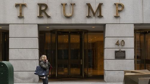 FILE - A woman walks past the Trump Building in New York's financial district, Wednesday, Jan. 13, 2021. Mazars USA LLP, the accounting firm that prepared former President Donald Trumps annual financial statements, says the documents should no longer be relied upon after investigators said they found evidence he and his company regularly misstated the value of assets. (AP Photo/Mark Lennihan, File)