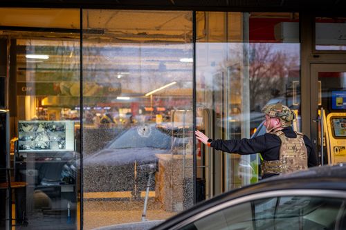 Un agente di polizia ispeziona il luogo in cui un uomo armato ha ucciso almeno sei persone per strada prima di essere ucciso dalla polizia, a Kiev