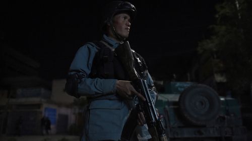 An Afghan police officer stands watch outside the Park Place guesthouse, following the attack. (Getty Images)