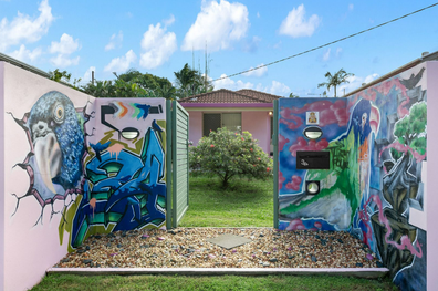 A three-bedroom family home with a very unusual pink graffiti art exterior has gone on the market and is expected to sell for just under $1million
