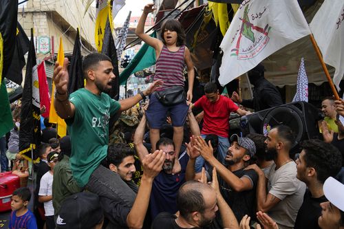 People dance in celebration of the attacks that the militant Hamas group carried out against Israel, at Bourj al-Barajneh Palestinian refugee camp, in Beirut, Lebanon, Saturday, Oct. 7, 2023.  