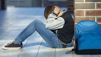 schoolboy crying in the hallway of the school, negative emotion