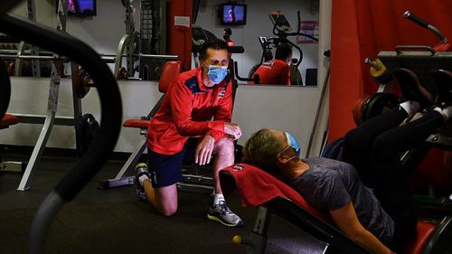 Joel Baur owner of Vision Personal Training in Pyrmont, Sydney with the morning's first client training in the studio. People who are fully vaccinated can now train indoors at a gym. 