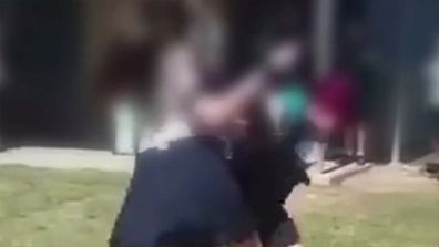 A Queensland father has shared a "confronting" video of his daughter involved in a brawl with an older pupil on school grounds, claiming teachers were forced to just watch because of school regulations.