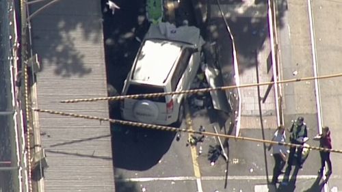 Aerial footage shows the damage to the car as shocked pedestrians look on. (9NEWS)