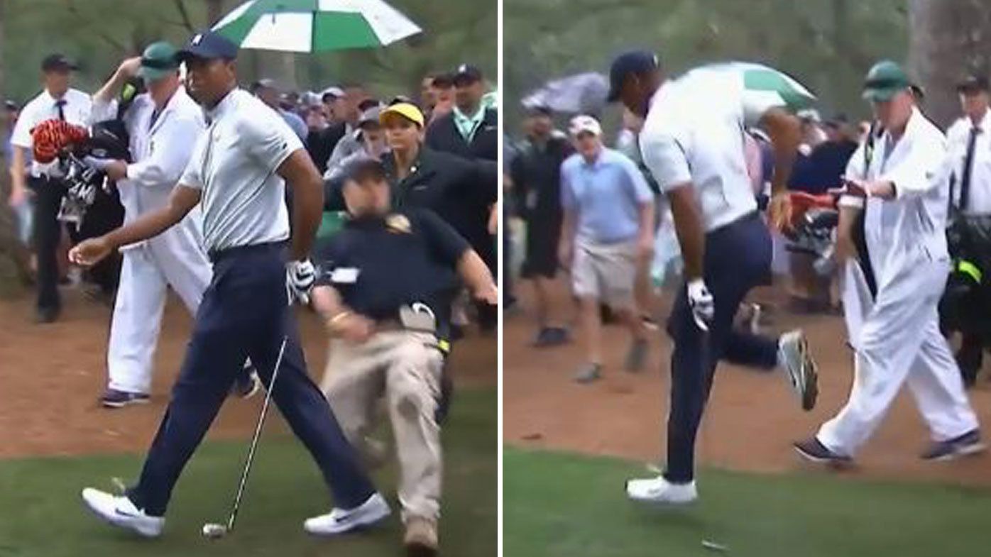 A security guard collides with Tiger Woods during the second round of the Masters.