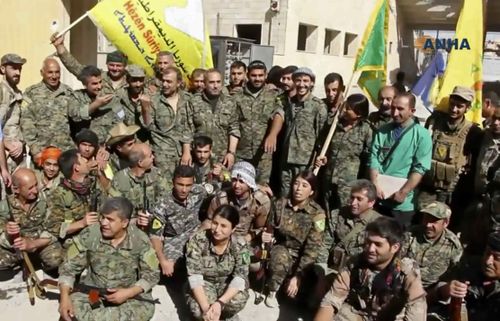 This frame grab from video released Tuesday, Oct. 17, 2017 and provided by Hawar News Agency, a Syrian Kurdish activist-run media group, shows fighters from the U.S.-backed Syrian Democratic Forces (SDF) celebrating their victory in Raqqa,