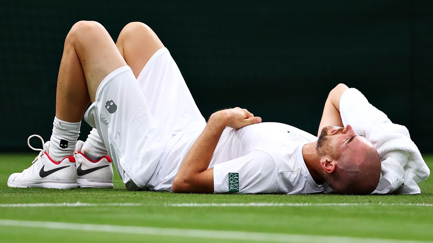 Adrian Mannarino of France reacts as he goes down with an injury in his Men&#x27;s Singles First Round match against Roger Federer of Switzerland during Day Two of The Championships - Wimbledon.