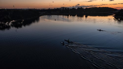 Kayakers exercising at dawn on Narrabeen Lagoon.