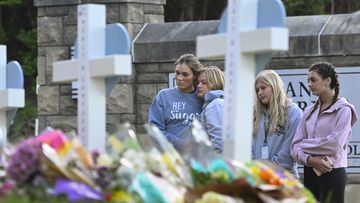Students at a nearby school pay respects at a memorial for the people who were killed, at an entry to Covenant School, Tuesday, March 28, 2023, in Nashville, Tenn.