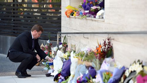 NSW Police Minister Troy Grant looks at flowers placed for police employee Curtis Cheng outside of the NSW Police Headquarters in Sydney on Tuesday, Oct. 6, 2015. Mr Cheng died at the scene after being shot by 15-year-old gunman Farhad Jabar Khalil Mohammad, was killed by officers responding to the shooting.