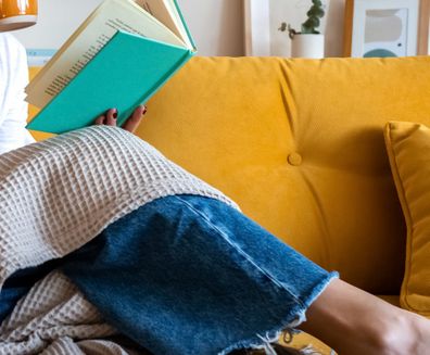 woman reading book on lounge