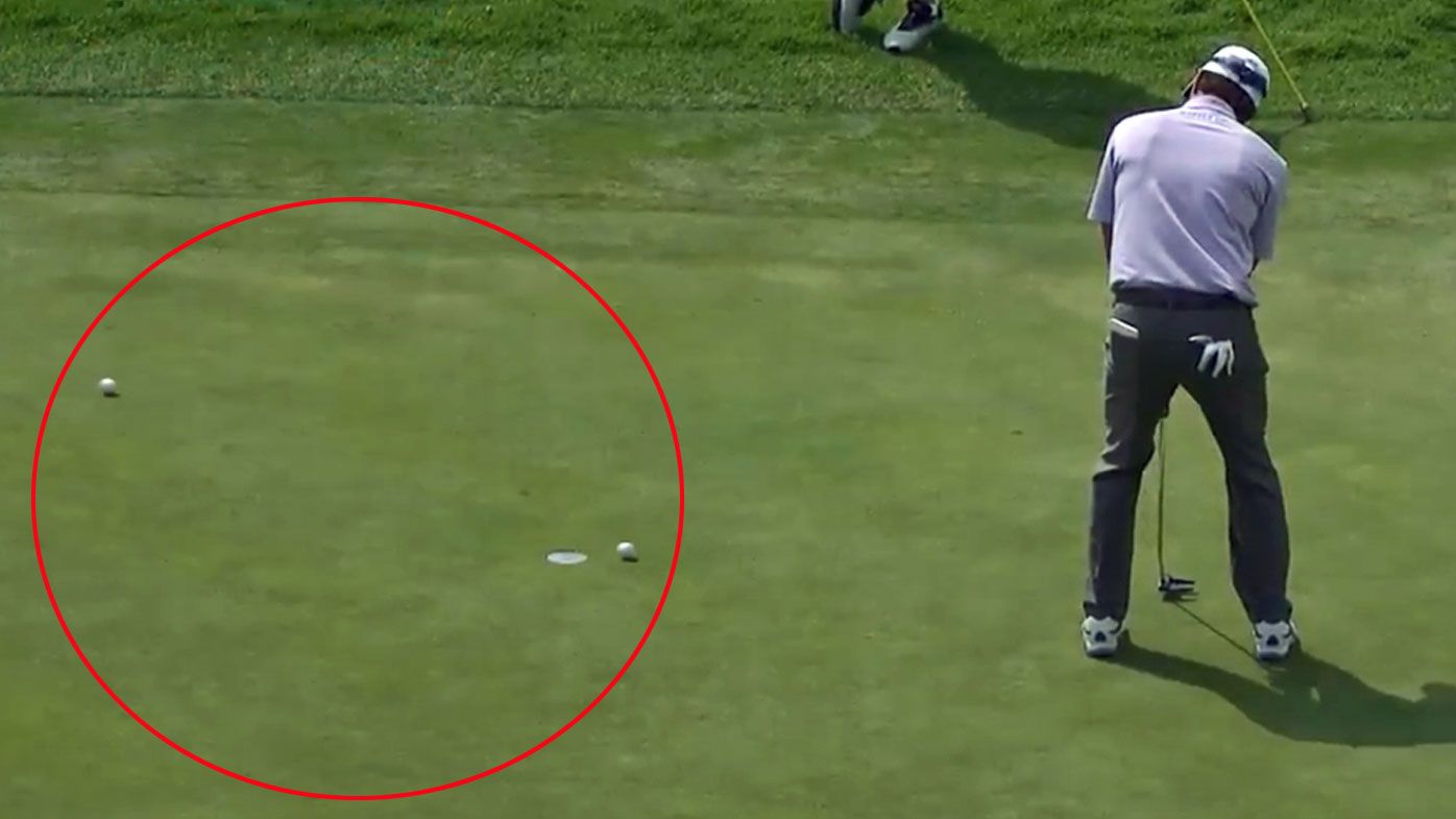 Kevin Kisner's ball is almost hit by a drive onto the green