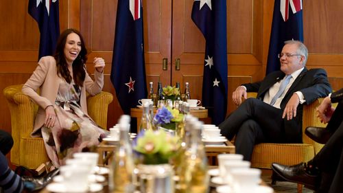 New Zealand Prime Minister and Australian Prime Minister Scott Morrison share a joke during their first face-to-face meeting in Singapore.