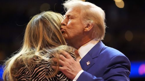 Republican presidential nominee former President Donald Trump kisses former first lady Melania Trump stand on stage at a campaign rally at Madison Square Garden, Sunday, Oct. 27, 2024, in New York. (AP Photo/Alex Brandon)