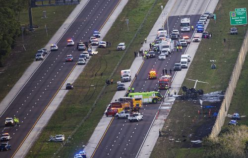 Emergency officials work the scene of a small plane crash on Interstate 75 in Naples, Fla., near Exit 105, Friday, Feb. 9, 2024. Two people were confirmed dead. 