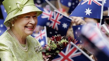 In 2006, Queen Elizabeth ll smiles amongst Australian flags at the Commonwealth Day Service March.
