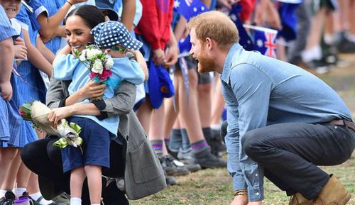 As the Royals worked their way along a line of schoolchildren from Dubbo, five-year-old Luke Vincent presented Meghan with flowers before embracing Harry.