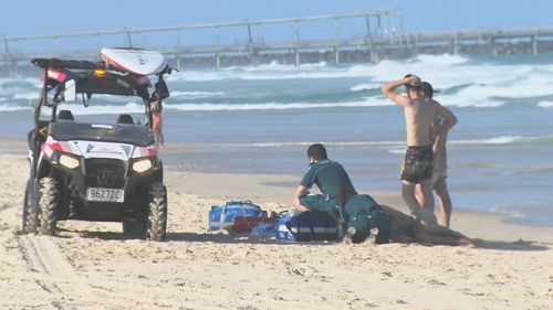 A man in his 20s has died and two others were taken to hospital, after three men were pulled from the water at The Spit on the Gold Coast.