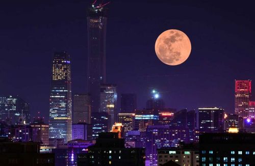 A super blood moon rises over buildings on January 31, 2018 in Beijing, China. (Photo: Getty)