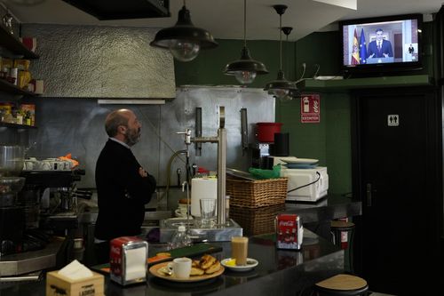 A bartender watches as Spanish Prime Minister Pedro Sanchez appears on a television broadcast in Madrid, Spain, Monday, April 29, 2024.
