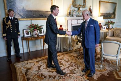King Charles III (right) shakes hands with the Chancellor of the Exchequer, Jeremy Hunt (left) in the private audience room at Buckingham Palace, London, England, Tuesday, March 5, 2024.