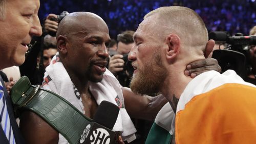 Mayweather and McGregor share an embrace after the fight. (AAP)