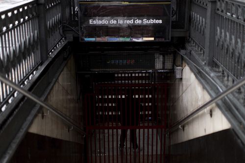 A subway employee stands in the closed entrance of the Buenos Aires's subway during a blackout, in Buenos Aires, Argentina.  (AP Photo/Tomas F. Cuesta)