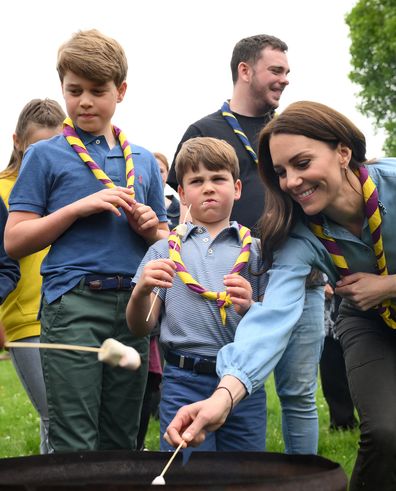 Prince George of Wales, Prince Louis of Wales and Catherine, Princess of Wales toast marshmallows as they take part in the Big Help Out, during a visit to the 3rd Upton Scouts Hut in Slough on May 8, 2023