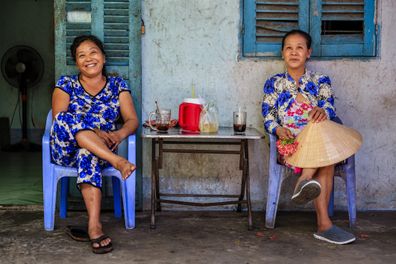 Two Vietnamese women drinking coffee together, Mekong River Delta, Vietnam