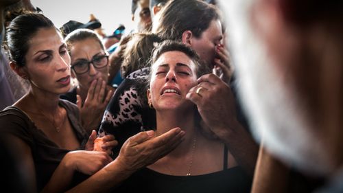 People mourn during the funeral of Dror Khenin in Yahud Monoson, Israel. Yesterday Khenin was the first Israeli to be killed by a Hamas mortar as he offered food to Israeli soldiers working near the Erez border crossing. Picture: Getty Images