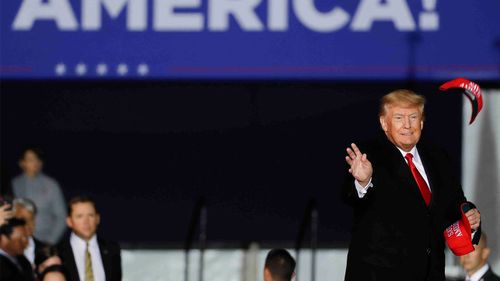 Donald Trump lancia un cappello alla folla durante una manifestazione in Texas.