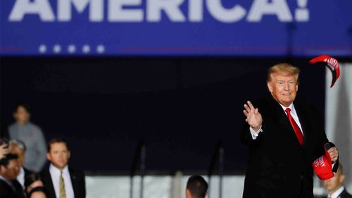 Donald Trump tosses a hat into the crowd at a rally in Texas.