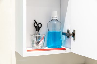 Inside a bathroom cabinet with mouthwash