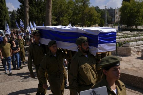 Israeli soldiers carry the flag-covered coffin of Maya Villalobo during her funeral at the military cemetery in Givatayim, Israel, Friday, Oct. 13, 2023. 