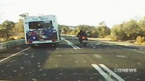 On the stretch of road at Kersbrook, the rider is seen crossing two solid white lines to overtake a vehicle. (9NEWS)