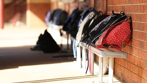 School bags lined up outside classroom.