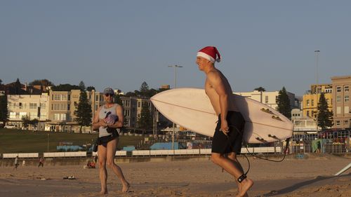 Un surfeur dans un bonnet de Noel à Sydney, en Australie, le jour de Noël.