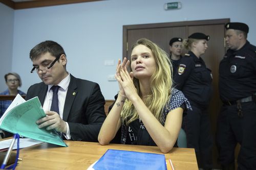 Veronika Nikulshina, center, a member of the feminist protest group Pussy Riot, attends hearings in a court in Moscow, Russia, Monday, July 23, 2018. Four members of the feminist protest group Pussy Riot, who had run onto the pitch dressed in police uniforms during the World Cup final, were sentenced in Moscow City Court on Monday. (AP Photo/Pavel Golovkin)