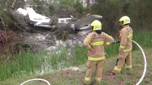 Fire crews attend to the wreckage of the plane. (9NEWS)