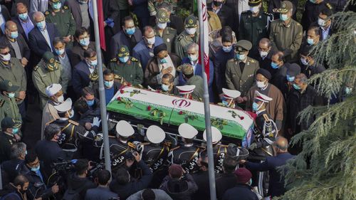 In this photo released by the official website of the Iranian Defense Ministry, military personnel carry the flag draped coffin of Mohsen Fakhrizadeh, a scientist who was killed on Friday, in a funeral ceremony in Tehran, Iran, Monday, Nov. 30, 2020. Iran held the funeral service for Fakhrizadeh, who founded its military nuclear program two decades ago, with the Islamic Republic's defense minister vowing to continue the man's work "with more speed and more power." (Iranian Defense Ministry via A