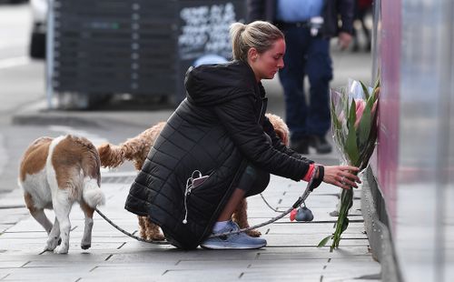 A woman lays flowers after the tourist was killed on Chapel Street.